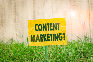 Word writing text Content Marketing Question. Business photo showcasing involves creation and sharing of online material Plain empty paper attached to a stick and placed in the green grassy land