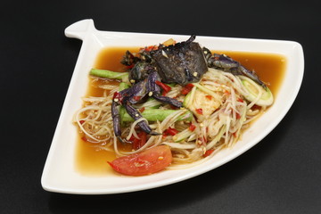 Somtum (Thai spicy salad) with black crab and vegetable in white plate