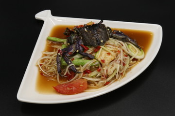Somtum (Thai spicy salad) with black crab and vegetable in white plate