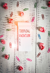 Writing note showing Tropical Vacation. Business concept for taking a holiday in countries either side of the equator Stripped ruled notepad clips paper balls wooden background