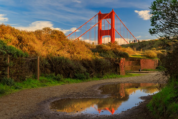 Panorama of the San Francisco Golden Gate bridge in the Marin Headlands California reflecting in a puddle after the rain - obrazy, fototapety, plakaty