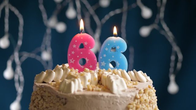 Birthday cake with 66 number pink candle on blue backgraund. Candles blow out. Slow motion and close-up view