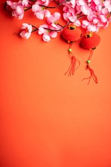 Chinese New Year background. Red Chinese lantern and pink flowers against red background. Copy space for text