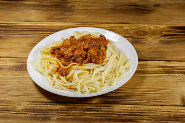 Pasta with bolognese sauce on wooden table