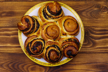 Sweet bun with poppy seeds on wooden table. Top view