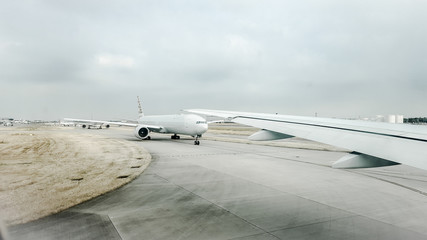 Commercial aeroplanes taxiing on a busy runway