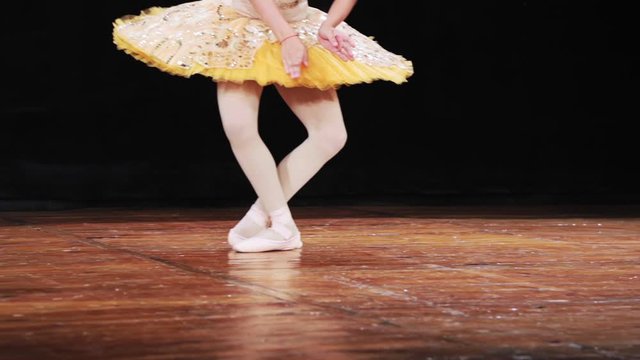 Little girl dancing ballet in a tutu and Pointe shoes. Close-up. Slow motion.