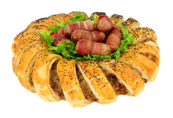 Puff pastry garland ring filled with seasoned pork sausage meat with pigs in blankets in the center isolated on a white background