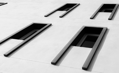 Obraz premium Looking up view of exterior modern building with glass window abstract. Real estate and corporate construction. Exterior architecture design. White concrete wall and glass window with unique design.