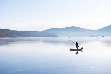 Fototapeta na wymiar Fisherman on the little boat in lake yamanaka morning