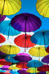 Fototapeta na wymiar Colorful umbrellas background. Multicolored umbrellas hanging above the street. 