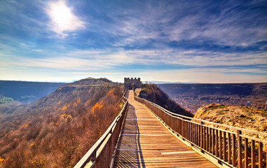 Beautiful view with wooden bridge leading to a stone gate of an ancient fortress