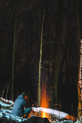 burning bonfire with soft glowing flame and sparkles flying all around. relaxing and enjoying the atmosphere, long exposure, hiking travel concept, vertical photo