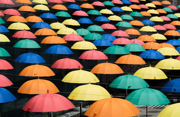 Colorful umbrellas background. Multicolored umbrellas hanging above the street. 
