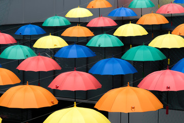 Colorful umbrellas background. Multicolored umbrellas hanging above the street. 