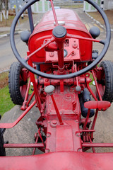 An ancient tractor from the 19th century. View of the cockpit with steering wheel and levers.
