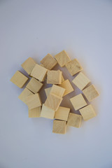 Pile of wooden blocks on pale purple background, small cubes made from wood