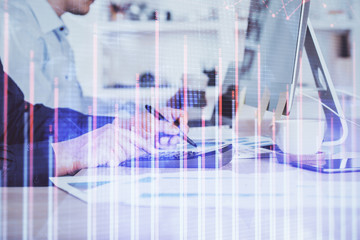 Forex graph with businessman working on computer in office on background. Concept of hardworking. Closeup. Multi exposure.