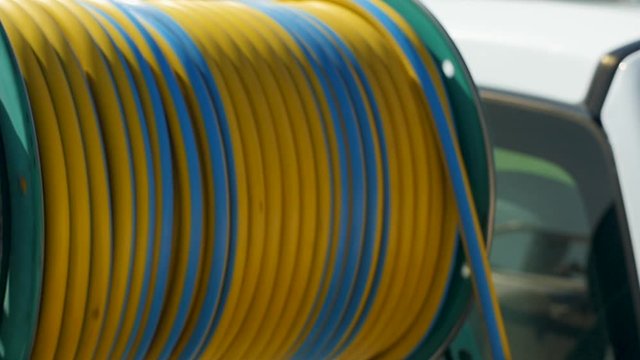Close up shot of the reel as it rolls the hose. This video shows the green automated reel as it rolls the yellow and blue hose.