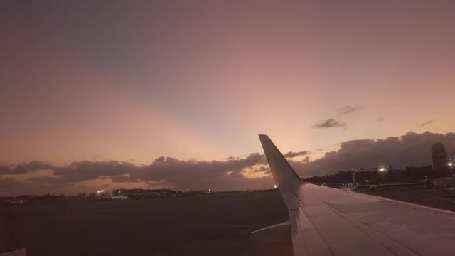 Caribbean airline flight on the runway with the wings facing the sunset before taking off from Princess Juliana International airport on the Caribbean island of Sint Marteen