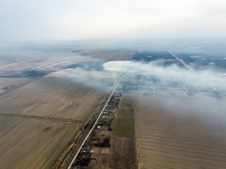 Top view of the small village. Smoke from the burning of straw i