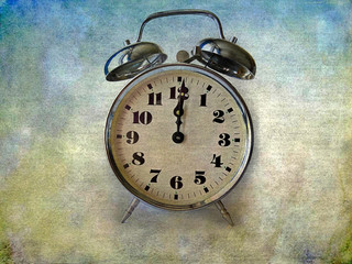 Twelve a clock on an old alarm clock on grunge background