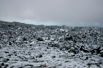 Top of Mount Etna volcano with snow, ash and volcanic rocks, Sicily, Italy