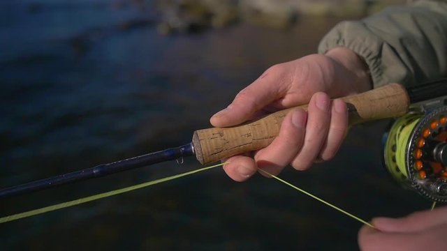 Closeup of fisherman retrieving his fly line in slow motion.

Footage is ideal to use in any project that depicts.  This footage will look great in your next video, Youtube video, or documentary.
