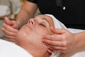 Fototapeta na wymiar Beautiful Young Woman Receiving Facial Massage.
