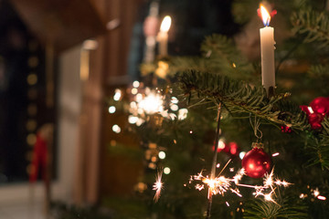 Fototapeta na wymiar Sparkler candle on christmas tree