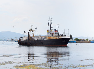 Fototapeta premium Ship in Sozopol port, Bulgaria. Sunny summer day, gulls flying, picturesque sky.