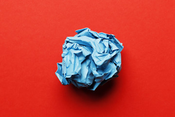 Blue paper ball on a red background.