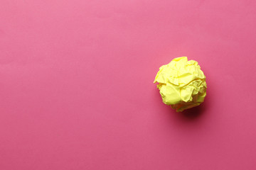 Yellow paper ball on a pink background.