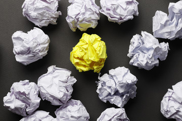crumpled paper balls and one yellow on a gray background. Place for text. Idea concept.