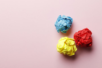 Multi-colored crumpled paper balls on a pink background. Place for text. Idea concept.