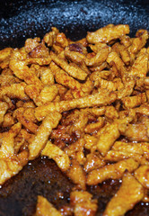 fried meat pieces mini. classic rustic meat dish in cast iron cookware