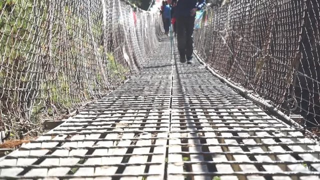 Video of a person walking across an iron bridge Suspension bridge