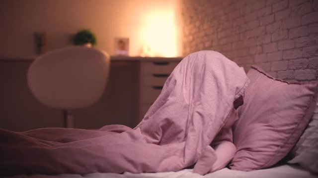 adorable little baby girl playing hide and seek in bed before going to sleep