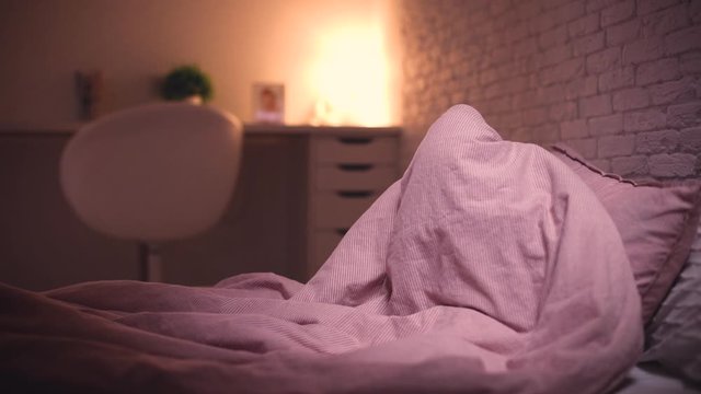 adorable little baby girl playing hide and seek in bed before going to sleep