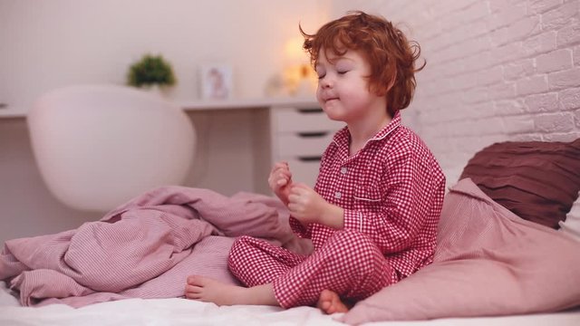 cute redhead toddler baby waking up in a good mood in the morning
