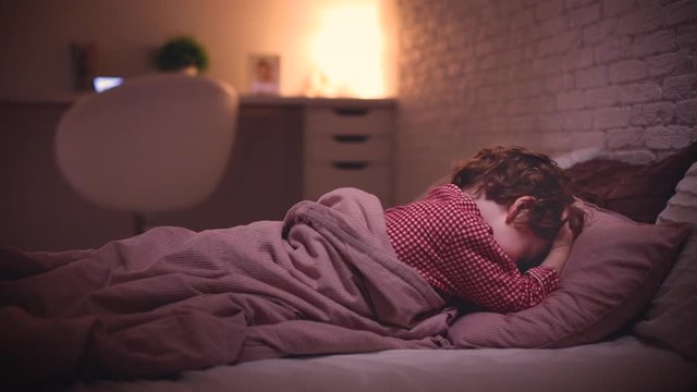 cute toddler baby boy in pajamas doesn't want to sleep when it is a bedtime