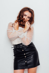 portrait of a beautiful fashionable woman with hair curls in a white blouse and black skirt