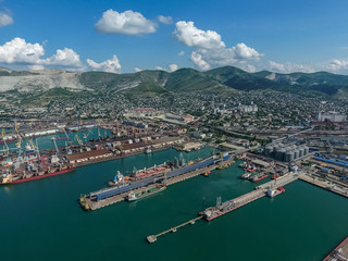 Industrial seaport, top view. Port cranes and cargo ships and barges.