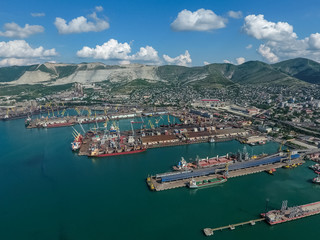 Fototapeta na wymiar Industrial seaport, top view. Port cranes and cargo ships and barges.
