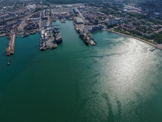 Obraz premium Industrial seaport, top view. Port cranes and cargo ships and barges.