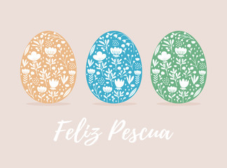 Happy Easter-Feliz Pescua, Spanish Easter Wishes. Cute Eggs in 3 Diferent Colors Isolated on a Beige Background. Pale Yellow, Blue and Green Eggs with and White Hand Drawn Floral Ornament Inside. 