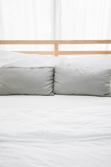 comfy wooden bed for couple decorated with pillows cosy bedroom at home valentines day, romantic date and holidays concept