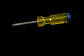 Screwdriver with a yellow and blue handle isolated on a black background