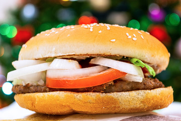 Hamburger with a cutlet in a rustic style on the background of a Christmas tree. Healthy organic food. White background. Prepare the soil. Very tasty food. Dietary food. Healthy dinner, lunch. 