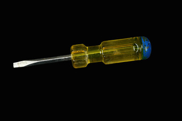 Screwdriver with a yellow and blue handle isolated on a black background